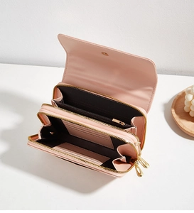 Dettaglio interno del portafoglio rosa con scomparti per carte e tasche con zip dorate