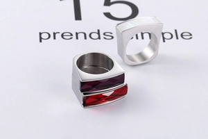 Detailed macro view of wide titanium steel rings featuring mother of pearl and gemstones