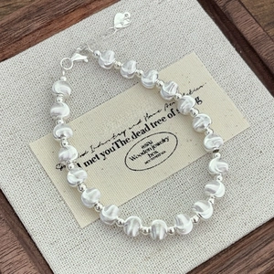 Macro shot of S925 sterling silver beaded bracelet with heart charm and lobster clasp