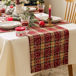 Red plaid Christmas table runner with white snowflake pattern for holiday dining decor