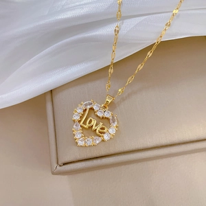 Luxurious gold heart pendant necklace with Love engraving and zircon inlay on a silk background