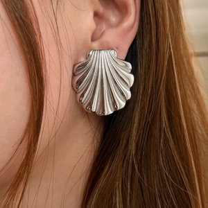 Chic silver shell-shaped stainless steel stud earrings for women on model