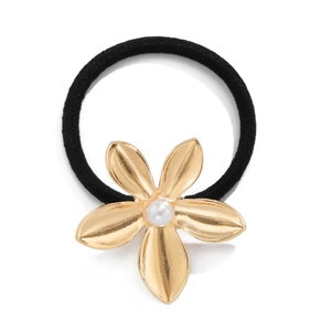 Detail of golden alloy five-petal flower hair tie with pearl center on black elastic band