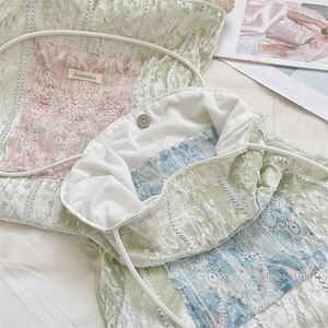 Detail of light green velvet tote bag with lace embroidery patches and magnetic closure