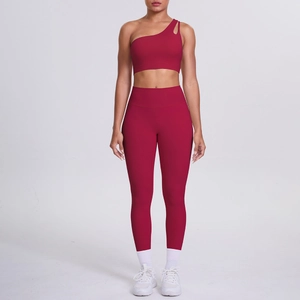 Detail of burgundy one-shoulder sports bra and high-waisted yoga pants fitness set