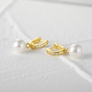 Macro shot of S925 sterling silver earrings with white pearl and micro-inlaid zircons