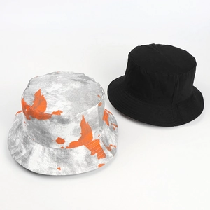 Detail view of tie-dye marble pattern and solid black cotton canvas bucket hats