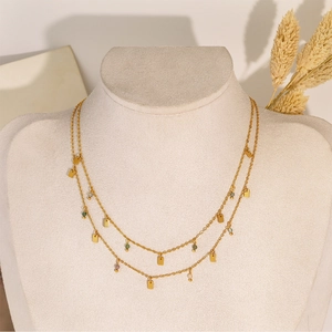 Detail of layered gold necklace with geometric square charms and multi-color beads