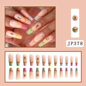 Detail view of long coffin press-on nails with nude base, colorful tips, and golden patterns