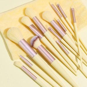 Professional 13-piece makeup brush set with yellow velvet pouch and rose gold accents