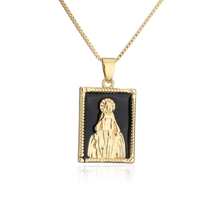 Detail of 18K gold plated necklace with Mary pendant and black enamel in macro view