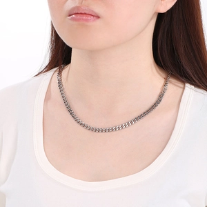 Polished silver cuban link chain necklace for men and women on white studio background