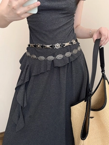 Close-up of vintage silver oval chain belt and black leather waist strap on a model