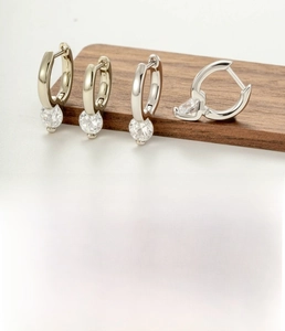 Detail view of coffee gold copper hoop earrings with cubic zirconia and clasp design