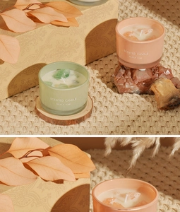 Close-up of scented candles with crystal stones in glass jars on a rustic wood base