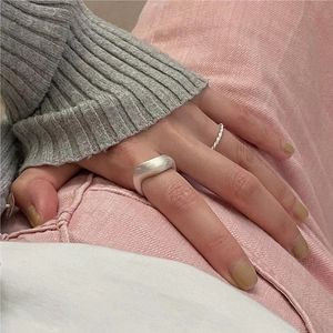 Close-up of minimalist S925 sterling silver twist and smooth ring set on finger