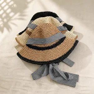 Straw sun hat details in three colors with checkered ribbons in a French holiday style