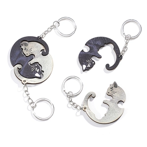Detail of wooden interlocking cat keychains forming a balanced yin yang circle