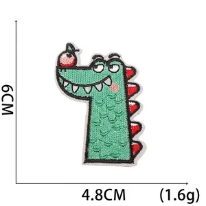 Close-up of green cartoon crocodile patch with red apple embroidery and 6cm size mark