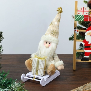 Detail of Christmas gnome with beige knit hat on wooden sled holding a gold gift box