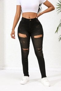 Gros plan d'un jean noir taille haute montrant la texture denim et les détails déchirés