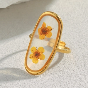 Detailed close-up of 18K gold plated oval ring with real yellow flowers in resin