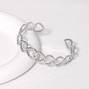Minimalist silver stainless steel open cuff bracelet featuring heart-shaped cutout design