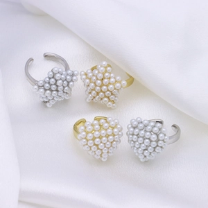 Elegant gold and silver star and heart open rings with white pearls on white silk