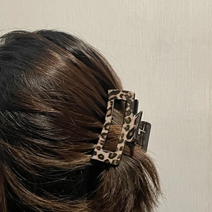 Detail view of rectangular leopard print hair claw clip in a stylish back hairstyle