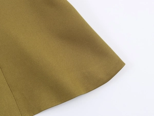 Close-up of olive green woven fabric texture and high-quality stitching on blazer