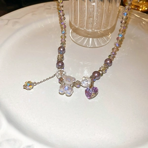 Close-up of purple crystal bear necklace with heart charms and shimmering pearls