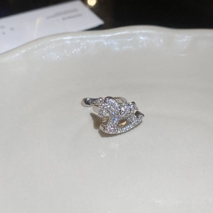 Macro shot of silver rocking horse ear cuff with zircon paving on beige ceramic dish