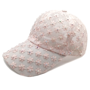 Close-up of pink floral embroidery and sparkling rhinestones on mesh sun hat fabric