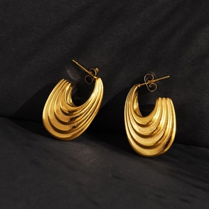 Chic hollow oval tiered gold earrings in vintage stainless steel on black surface