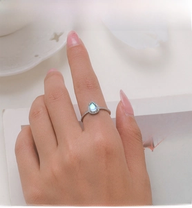 Detailed view of pear-cut moonstone ring with pave zircons on silver band