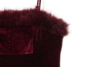Detail of burgundy velvet midi dress with faux feather trim and purple rhinestones