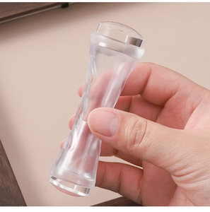 Detail of hand-held dual-headed clear silicone nail stamper tool with curved handle