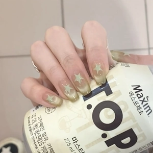 Short square press-on nails with green cat-eye gradient and star patterns