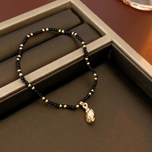 Detail of bohemian beaded necklace with golden oval pendant in a premium gift box
