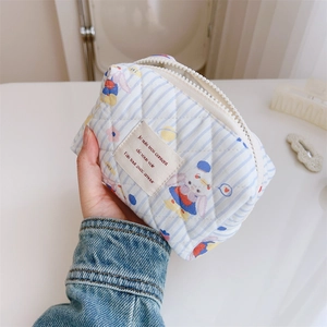 Gros plan sur la pochette matelassée en coton bleu clair avec motifs animaux et fermeture