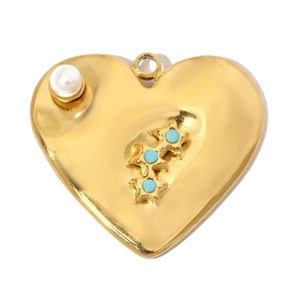 Detail showing polished gold heart pendant with white pearl and blue stones in macro view