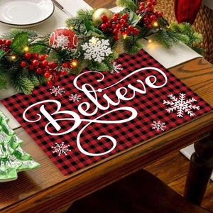 Christmas Believe placemat with red and black plaid pattern on a rustic wooden dining table