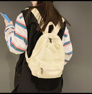 Modell mit minimalistischem cremefarbenem Segeltuch-Rucksack mit Doppelreißverschluss