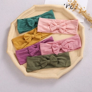 Flat lay of colorful plush star headbands for babies in a minimalist tray