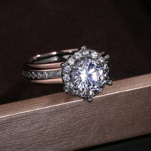 Macro detail of two-tone halo ring with round zircon and pavé side stones on dark display