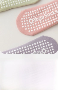 Detailansicht der rutschfesten Silikon-Gripper und Yoga Socks Text auf Baumwollstoff