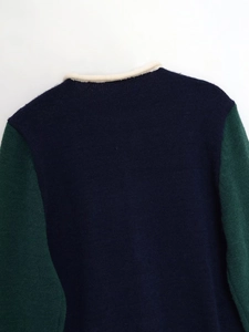 Detail of round neckline and color block stitching on navy blue knitted sweater