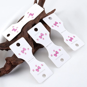Strawberry and pink bow pattern paper cards for jewelry packaging on dark wood background