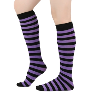 Detail view of purple and black striped knee-high socks with elastic cuffs on model