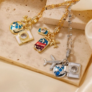 Macro detail of travel theme necklace featuring enamel globe, plane and camera charms
